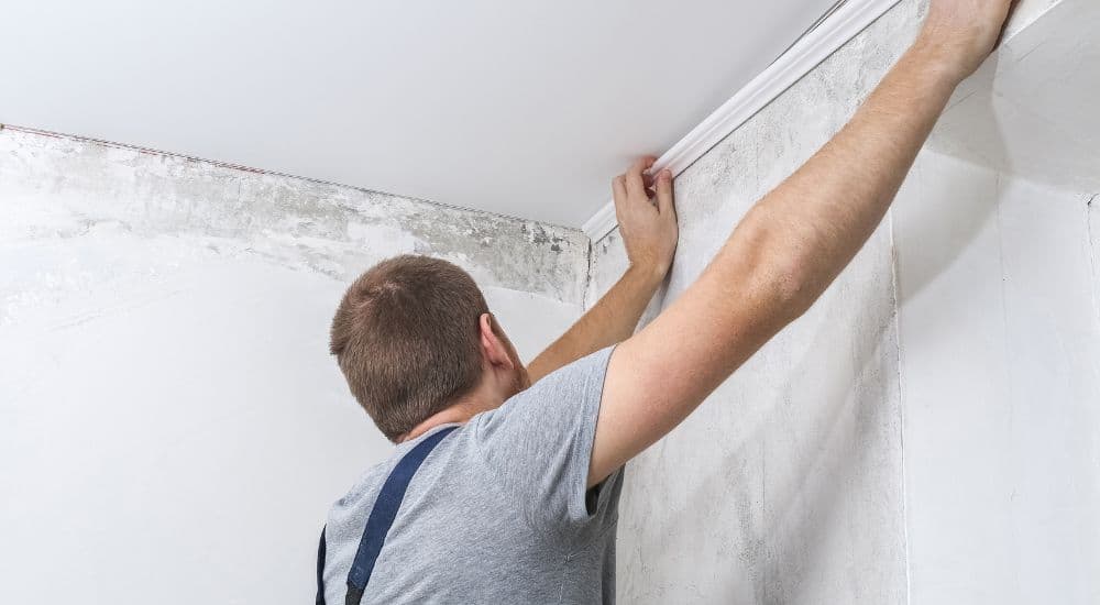 Contractor installing new trim and drywall after water damage restoration