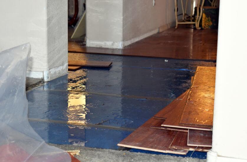 Emergency water damage with standing water flooding hardwood floors